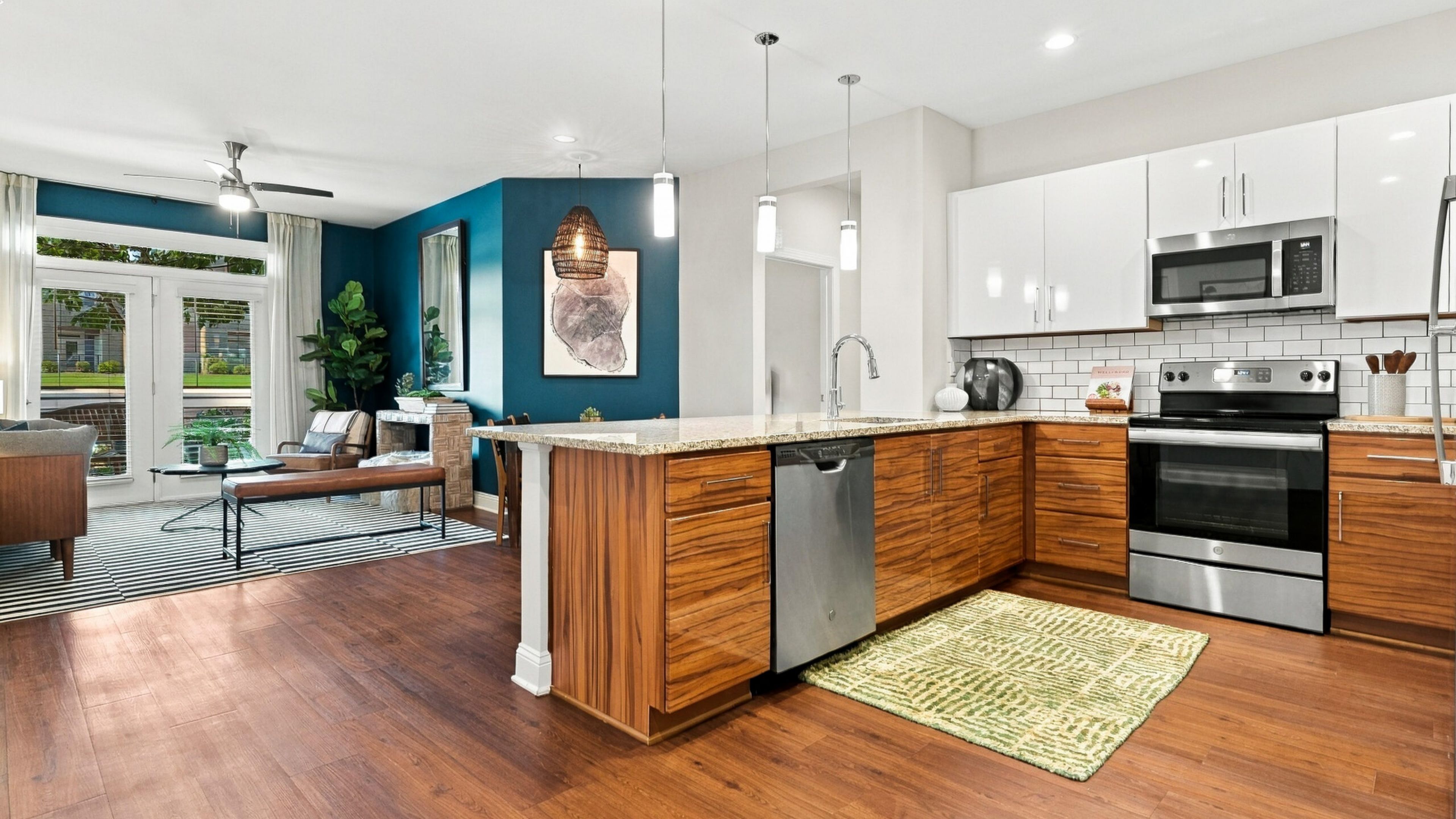 Hawthorne at Haywood apartment kitchen and living area with quartz countertops, stainless steel appliances, and ample cabinet storage