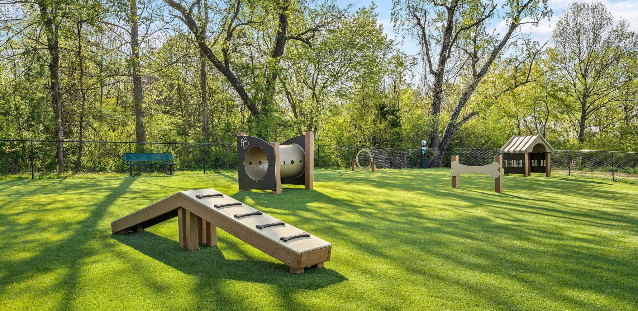 Hawthorne at Haywood outdoor dog park space with obstacle course and surrounding benches