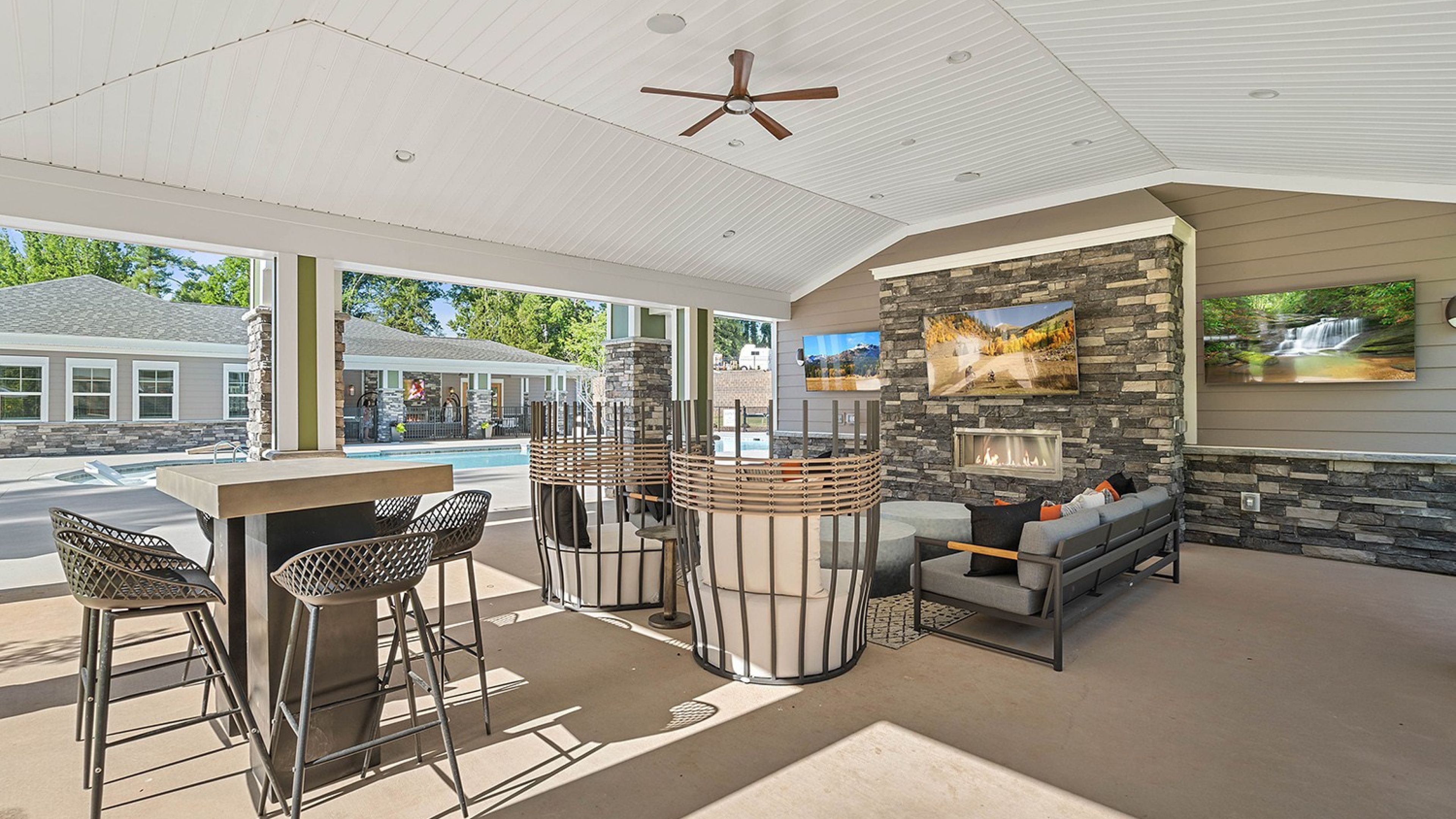 Hawthorne at Haywood outdoor fireplace with lounge chairs, tv, and dining space